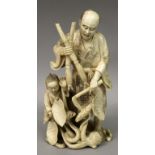 A GOOD QUALITY SIGNED JAPANESE MEIJI PERIOD IVORY OKIMONO OF A MAN & HIS SON, confronting a snake