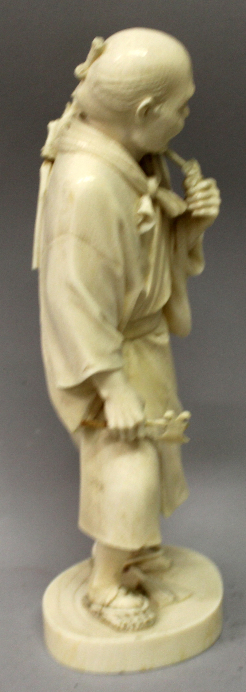 A LARGE GOOD QUALITY JAPANESE MEIJI PERIOD TOKYO SCHOOL IVORY OKIMONO OF A STANDING MAN, holding - Image 2 of 8