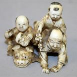 A GOOD QUALITY JAPANESE MEIJI PERIOD IVORY OKIMONO OF A MAN & TWO BOYS, one child holding grapes and