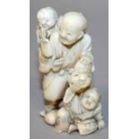 A SIGNED JAPANESE MEIJI PERIOD IVORY OKIMONO OF A STANDING MAN & TWO BOYS, one boy carried on the