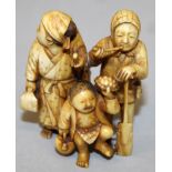 A GOOD QUALITY JAPANESE MEIJI PERIOD STAINED IVORY OKIMONO OF A FAMILY GROUP, bearing various
