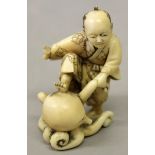A JAPANESE MEIJI PERIOD IVORY OKIMONO OF A MAN & AN OCTOPUS, the standing man holding a tentacle and