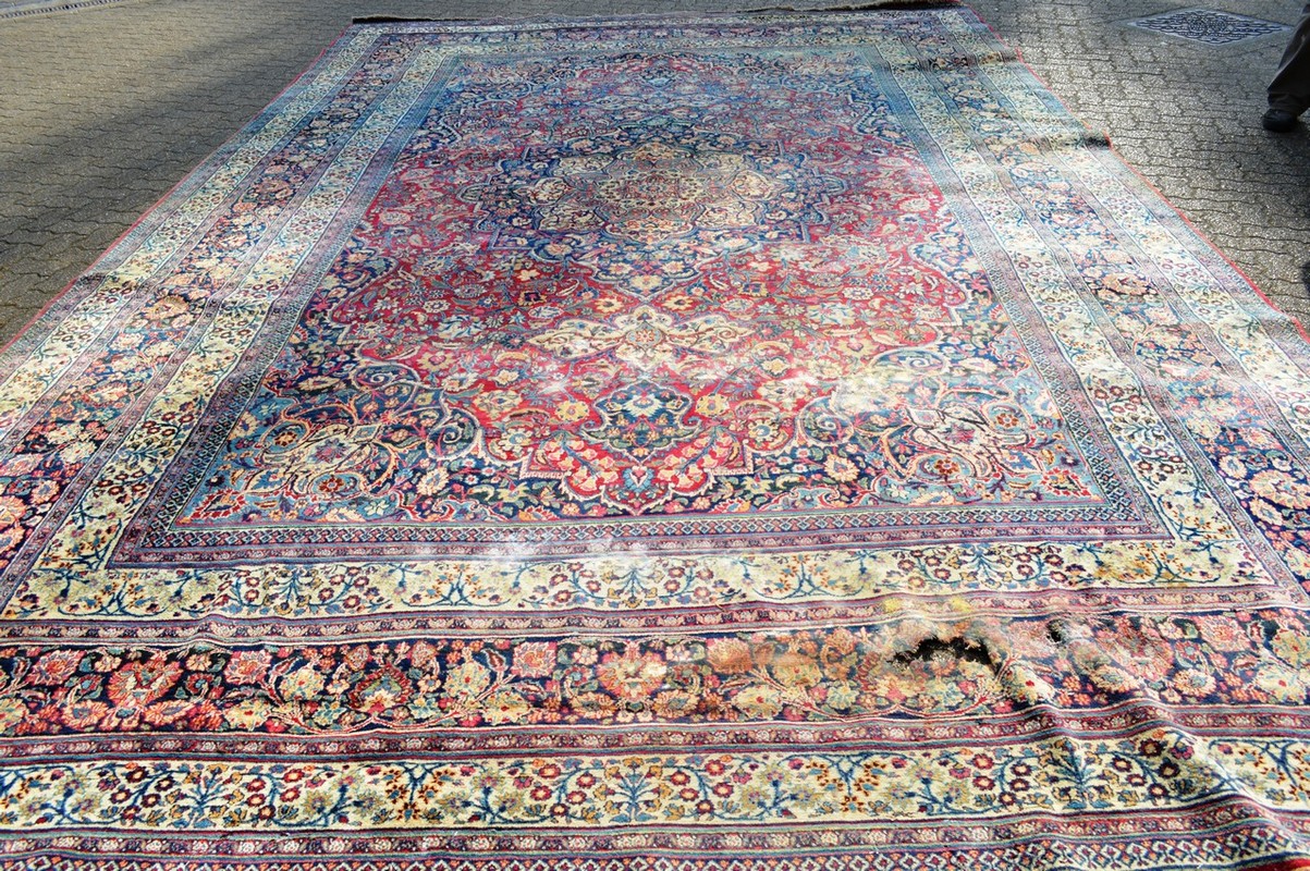 A LARGE PERSIAN MESHED CARPET, red ground within a triple row border, all over stylised floral