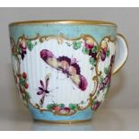 AN 18TH CENTURY WORCESTER COFFEE CUP painted with fruit and butterflies on a ribbed body, Crescent