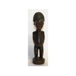 A CARVED WOOD TRIBAL FIGURE OF A MAN. 11.5ins high.