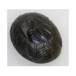 A SOUTH AMERICAN CARVED COCONUT BOWL, with a portrait of a man. 11cms long, 8cms wide.