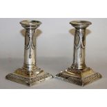 A PAIR OF CLASSICAL CANDLESTICKS on square bases. 8ins high. London 1901.