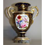 AN EARLY 19TH CENTURY DERBY TWO HANDLED VASE painted with flowers on a blue ground.
