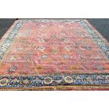 A PERSIAN TABRIZ CARPET, pink ground within a single blue ground border, with stylised floral