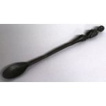 A LONG CARVED WOOD AFRICAN SPOON with figured handle. 16ins long.