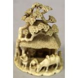 A SMALL GOOD QUALITY SIGNED JAPANESE MEIJI PERIOD IVORY OKIMONO OF A VILLAGE HUT, overshadowed by