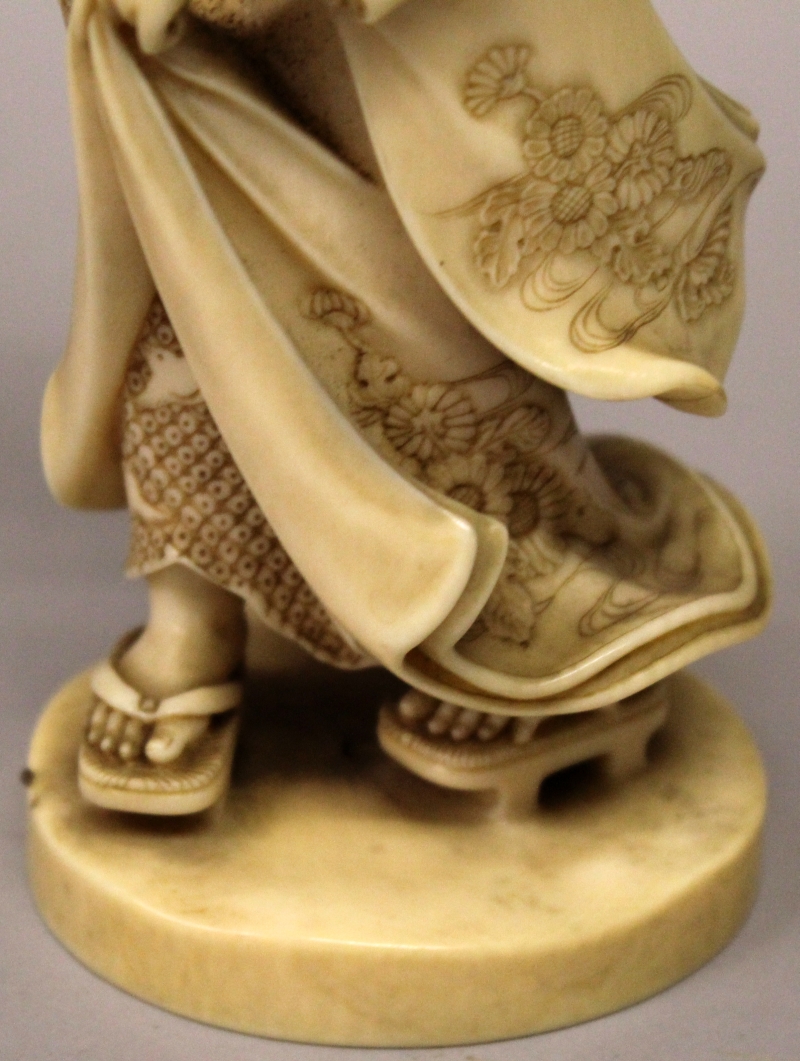 A GOOD QUALITY SIGNED JAPANESE MEIJI PERIOD IVORY OKIMONO OF A BIJIN, walking on geta in floral - Image 6 of 7