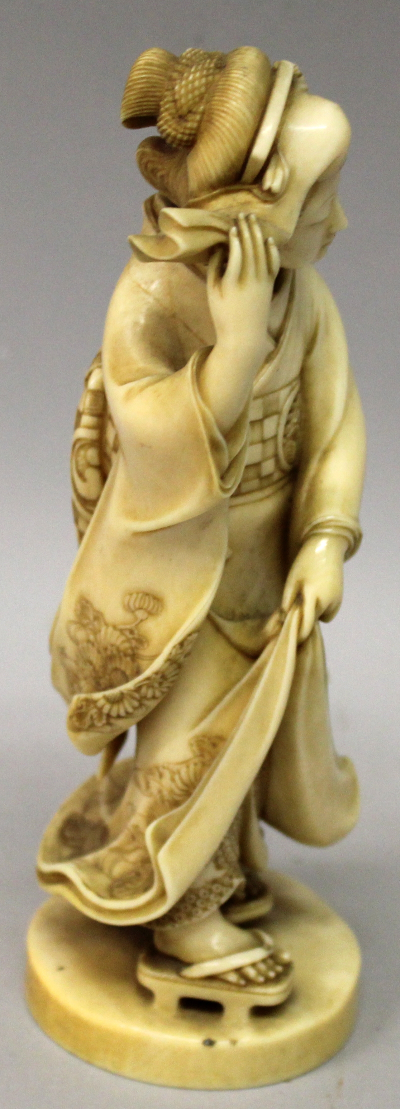 A GOOD QUALITY SIGNED JAPANESE MEIJI PERIOD IVORY OKIMONO OF A BIJIN, walking on geta in floral - Image 2 of 7