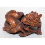 A GOOD QUALITY 19TH/20TH CENTURY SIGNED JAPANESE CARVED WOOD OKIMONO OF A COILED DRAGON, with inlaid