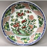 A LARGE CHINESE KANGXI PERIOD FAMILLE VERTE PORCELAIN SAUCER DISH, the interior painted to its