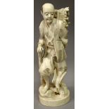 A SIGNED JAPANESE MEIJI PERIOD IVORY OKIMONO OF A WOODSMAN, standing on rockwork with a hawk at