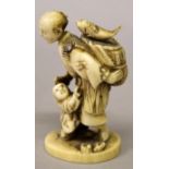 A SMALL JAPANESE MEIJI PERIOD IVORY OKIMONO OF A FISHERMAN & HIS SON, the man carrying a basket of