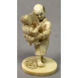 A SIGNED JAPANESE IVORY OKIMONO OF A MAN & A CHILD, the standing man holding the boy up in his arms,