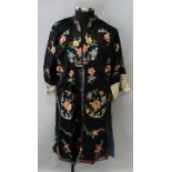 AN EARLY 20TH CENTURY CHINESE EMBROIDERED BLACK GROUND SILK ROBE, decorated in vivid colours with