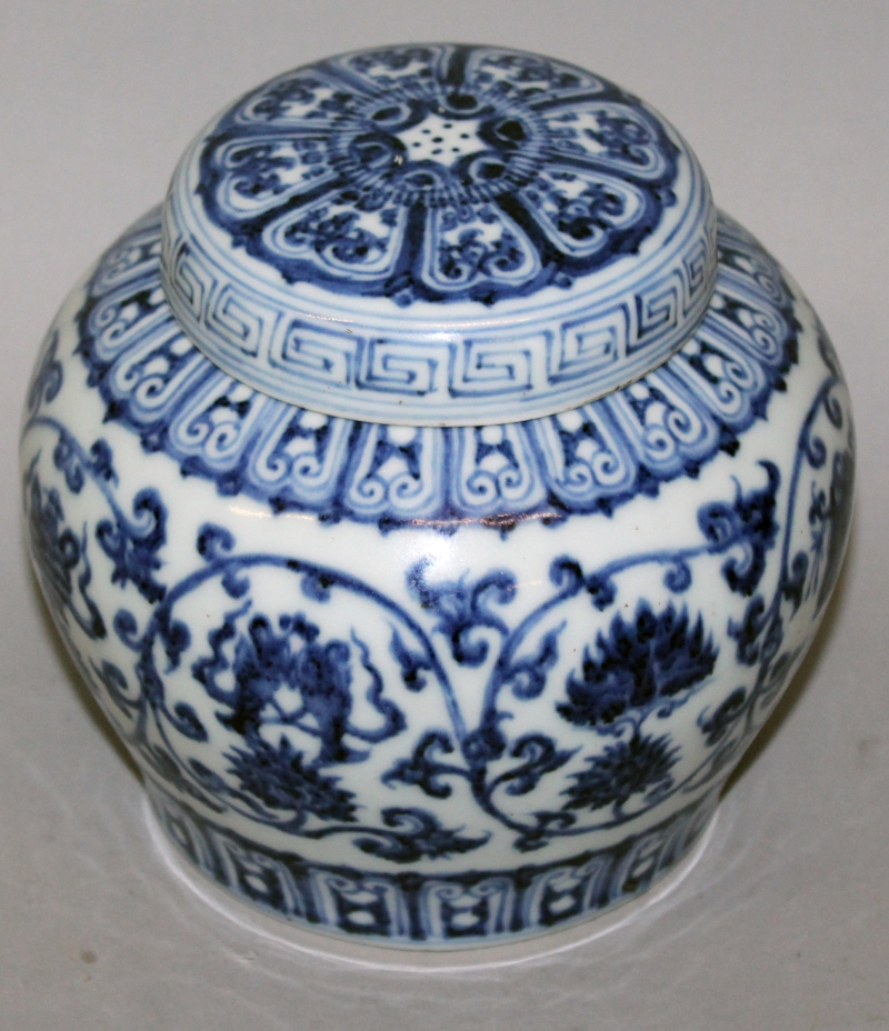 A CHINESE MING STYLE BLUE & WHITE PORCELAIN JAR & COVER, the sides decorated with a formal design of