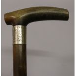 A 19TH CENTURY RHINOCEROS HORN HANDLED WOOD WALKING STICK, with an engraved silver-metal collar, the