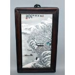 A CHINESE WOOD FRAMED SNOW SCENE PORCELAIN PLAQUE, decorated with calligraphy and a riverside