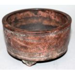 A CHINESE YIXING POTTERY TRIPOD CENSER, the sides incised with calligraphy and a foliate spray,