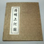 A CHINESE PICTURE BOOK, with fabric covers, opening to reveal a long folding continuous scene on