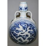 A CHINESE MING STYLE BLUE & WHITE PORCELAIN MOON FLASK, each side decorated with a dragon against