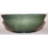 A CHINESE SPINACH GREEN JADE-LIKE BOWL, the sides decorated in relief with formal scrolling lotus,