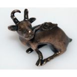 AN 18TH CENTURY CHINESE BRONZE SCROLL WEIGHT, in the form of a seated deer, a frond held in it's