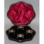 A SET OF SIX PLAIN CIRCULAR SALTS with glass liners, on three bun feet, in a fitted case. London