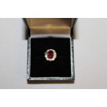 A LOVELY RUBY AND DIAMOND OVAL CLUSTER RING in 18ct white gold and platinum.