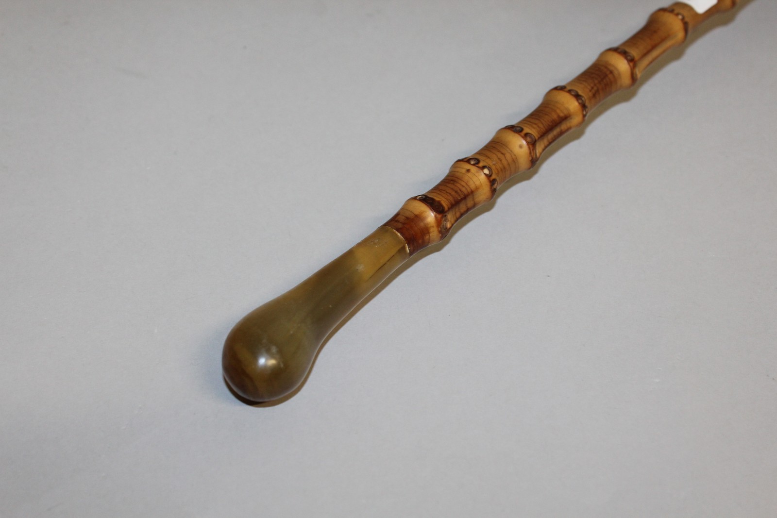 A HORN HANDLED BAMBOO WALKING STICK. 35ins long.