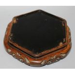 A CHINESE PADOUK WOOD OCTAGONAL STAND with pierced sides. 10ins diameter.