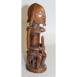 A CARVED WOOD TRIBAL FEMALE FIGURE, POSSIBLY ETHIOPIAN. 9ins high.