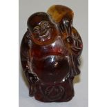 A CHINESE CARVED AMBER FIGURE. 2.75ins high.