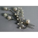AN 18CT WHITE GOLD AND PEARL SET FLOWER BROOCH.