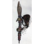 A TRIBAL SWORD in a leather scabbard.