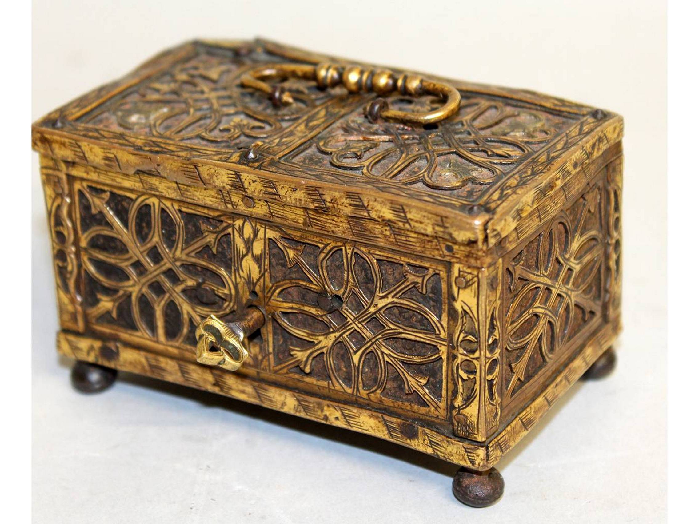 A RARE SMALL 16TH-17TH CENTURY FILIGREE BRONZE CASKET with metal interior, carrying handle on bun