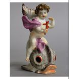 A SMALL MEISSEN GROUP OF A CUPID RIDING A DOLPHIN. Cross swords mark in blue. 4ins high.