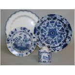 An 18th century English Delft plate, a blue and white charger, another charger with blue border