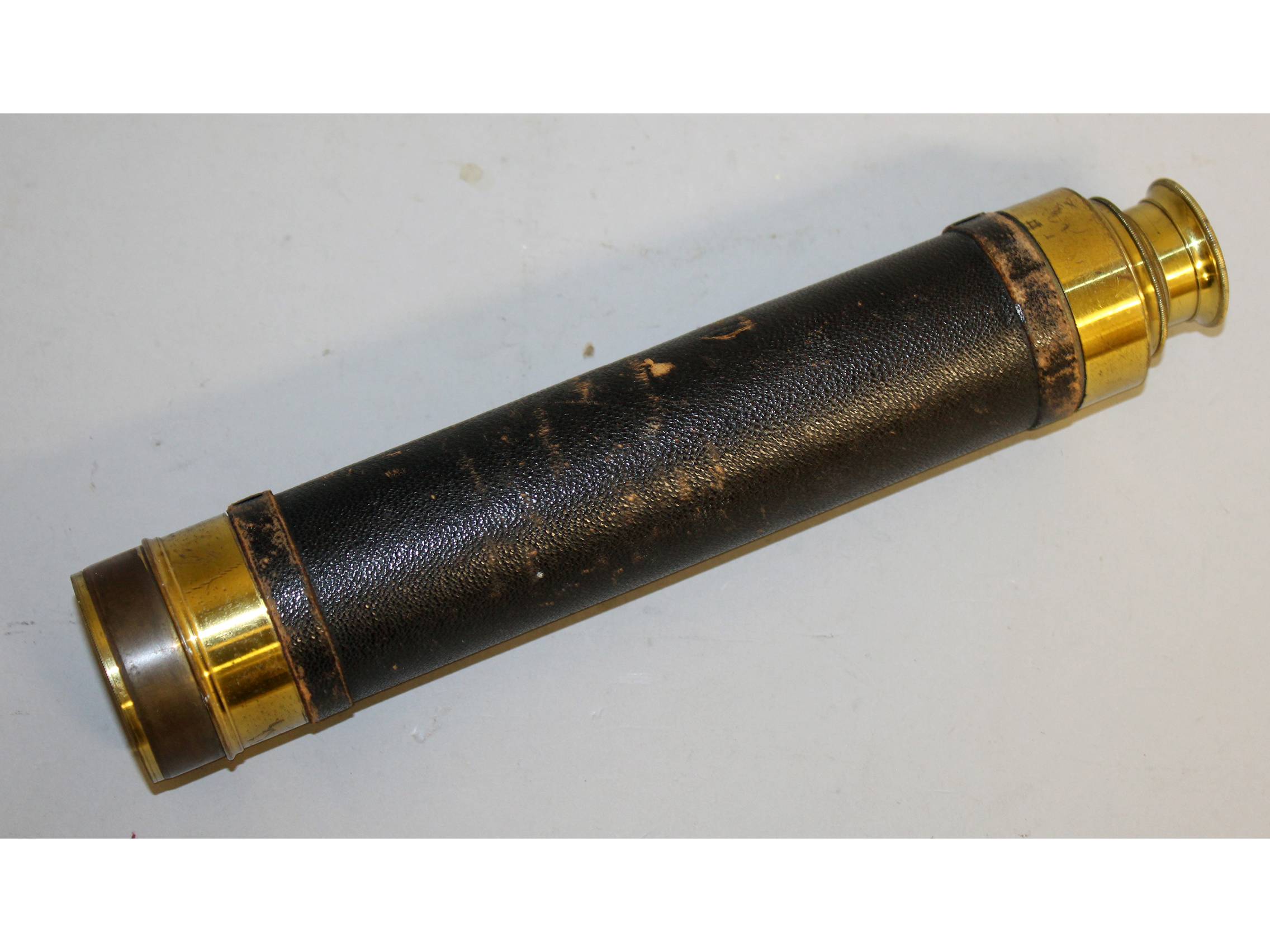 A 19TH CENTURY BRASS AND LEATHER FOLDING TELESCOPE.