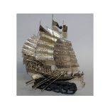 A 19TH/20TH CENTURY CHINESE SECTIONAL SILVER-METAL MODEL OF A JUNK, together with a fixed wood