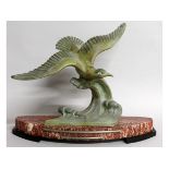 AN ART DECO GILDED GROUP OF A SEAGULL ON A WAVE, standing on a red bowfronted marble base. 18ins