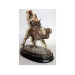 A LARGE VIENNA BRONZE "A MAN RIDING A CAMEL" on a wooden base. 14ins high.