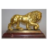 A SUPERB GILDED BRONZE LION on a scaglione marble base. 12ins long.