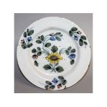 AN 18TH CENTURY ENGLISH DELFT WARE PLATE painted in Fackerley colours and decorated with a
