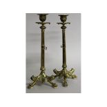 A GOOD PAIR OF FRENCH BRASS CANDLESTICKS on three paw feet. 12ins high.