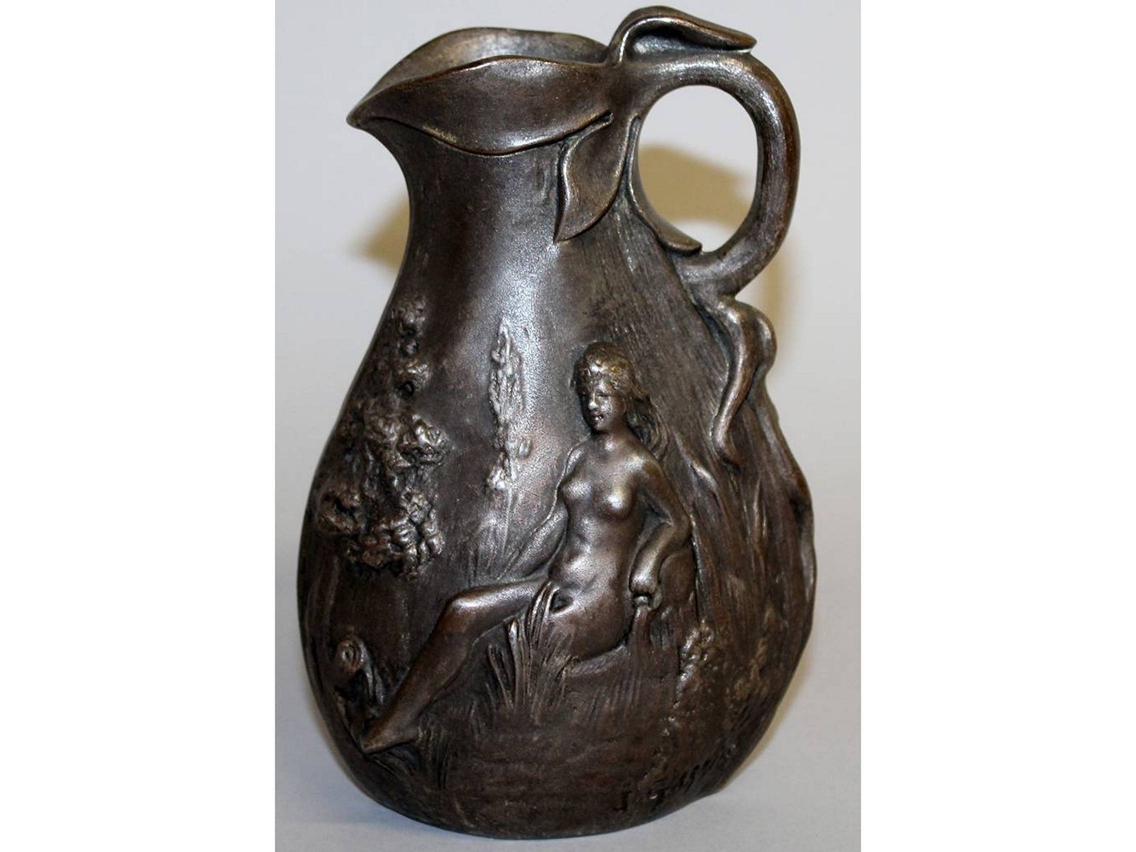 J. GARNIER. AN ART NOUVEAU METAL JUG, repousse with two nude seated female figures. Signed. 6.5ins